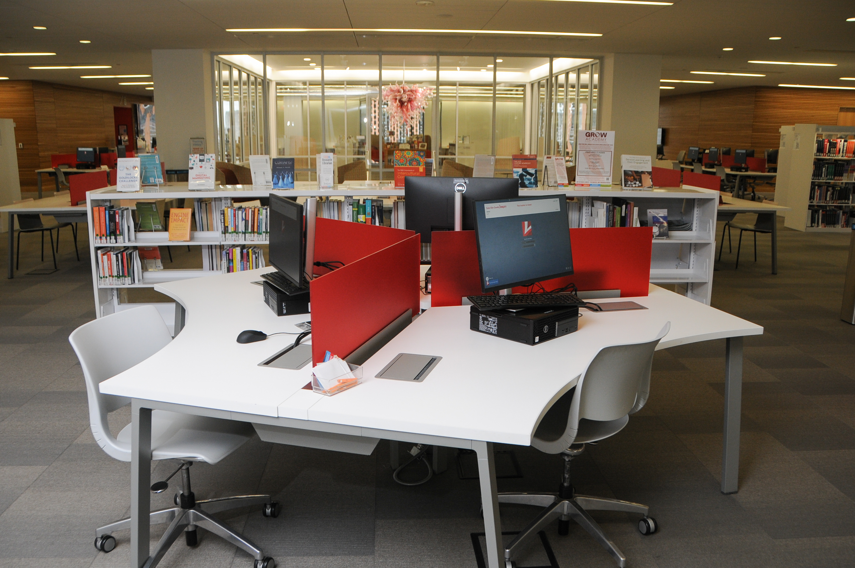 computer bank in front of library shelves