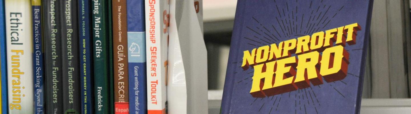 Library shelf with books about nonprofit fundraising, featuring a title called "Nonprofit Hero"