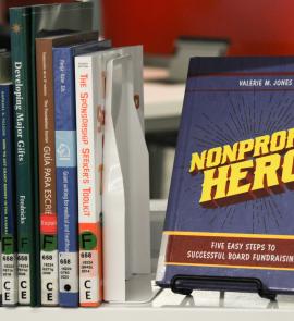 Spines of books about nonprofit fundraising and a faced out books called "Nonprofit Hero"