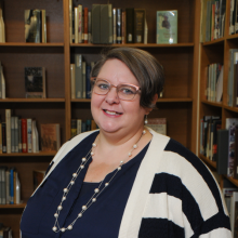 Heather in front of wooden bookshelves